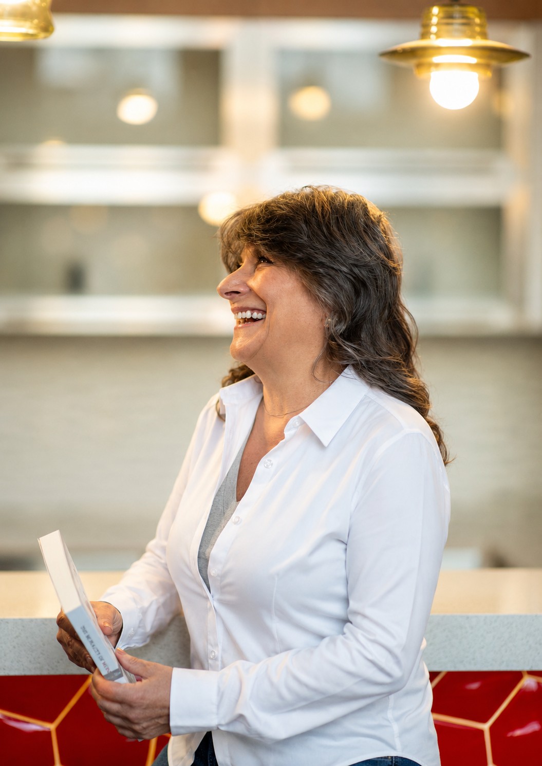 Renée E. Bryan laughing while holding her book